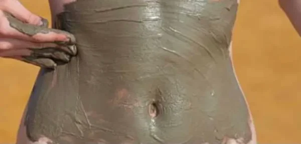 Close up shot of a girl applying something on stomach