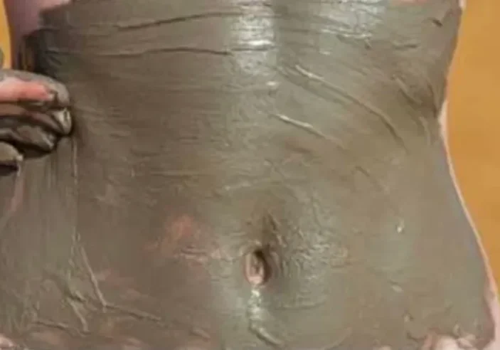 Close up shot of a girl applying something on stomach